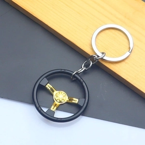 Detailed shot of a zinc alloy steering wheel keychain with black and gold metallic finish