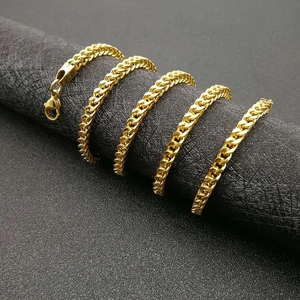 Polished vacuum-plated gold hip hop chain necklace wrapped on a black display stand