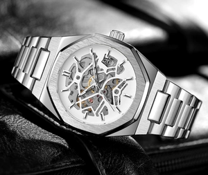 Macro detail of silver octagonal skeleton mechanical watch showing gears and metal strap