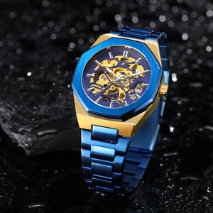 Macro shot of blue and gold skeleton automatic watch with water drops on dark surface
