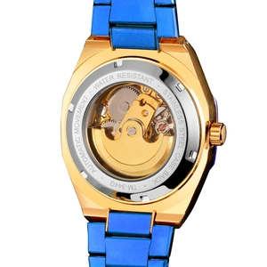 Detail view of the automatic mechanical movement and stainless steel back of a golden watch