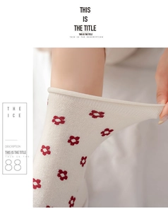 Detail showing the high elasticity and delicate red floral pattern on cream cotton socks