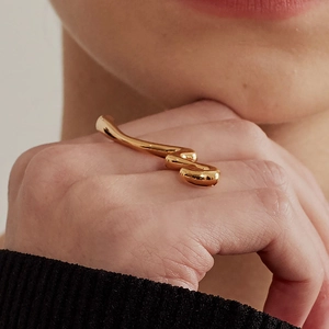 Minimalist 925 sterling silver ring with irregular gold wave design on finger