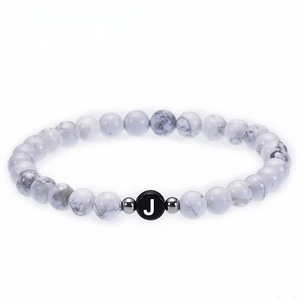 Detail of 6mm white turquoise beaded bracelet with silver spacers and a black letter J bead