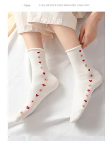 Detail view of white 100% cotton socks with cute heart and flower embroidery patterns