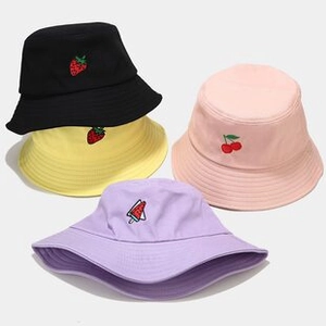 Detail view of colorful cotton bucket hats for kids with fruit embroidery and chin straps