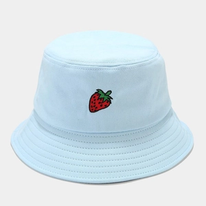 Détail d'une broderie fraise sur un chapeau bob en coton bleu clair avec coutures
