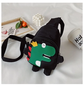 Close-up of black nylon kids crossbody bag featuring a green cartoon dinosaur and crown