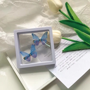 Blue-purple gradient butterfly hair clips in a white square floating display box