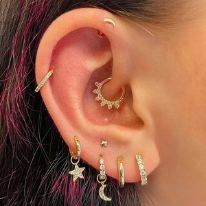 Golden celestial ear jewelry set with zircon star and moon pendants on a female model