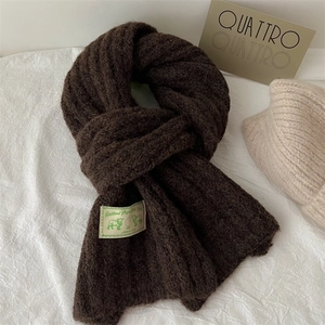 Detailed view of dark brown Shetland Virgin Wool knit scarf with texture and fabric tag