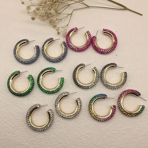 Colorful rhinestone C-shaped hoop earrings in gold setting with various vibrant colors