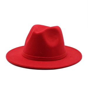 Detailed view of a red wool fedora hat with a wide brim and matching ribbon band