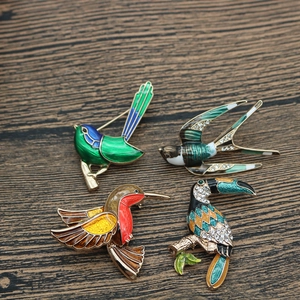 Detail of bird brooches featuring colorful enamel glaze and sparkling crystal accents