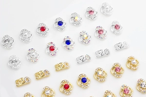 Detail of floral and 520 numbered nail jewelry with pearls and vibrant rhinestones