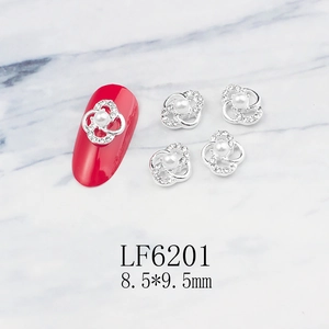 Macro shot of silver alloy flower nail art charm with white pearl and tiny rhinestones