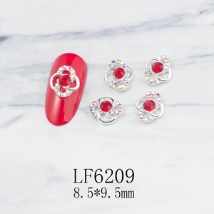 Macro shot of silver hollow spiral flower nail charms with red rhinestones and size data