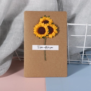 Detailed view of handmade kraft paper card with yellow artificial sunflowers and text