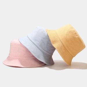 Minimalist soft towel fabric bucket hats in pink, light blue, and pale yellow colors