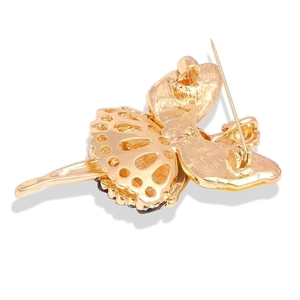 Back view of golden ballet girl brooch featuring secure pin clasp and hollow design