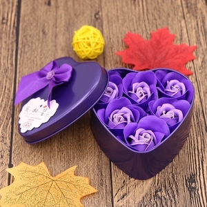 Macro shot of purple heart-shaped tin box featuring six soap roses and a silk bow