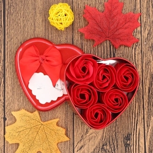 Macro shot of 6 soap roses in a heart-shaped tin box with a romantic greeting card