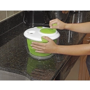 Manual salad spinner for vegetable dehydration on a black granite kitchen countertop