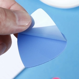 Detailed macro shot showing the adhesive white backing of a blue heart sticky note