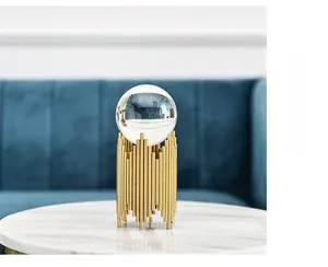 Luxury crystal ball decor with golden metal stand on a marble table in modern living room