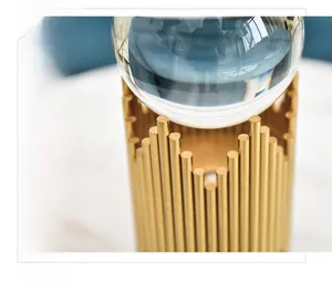 Detail of translucent crystal ball on wave-shaped golden metal base for home decor