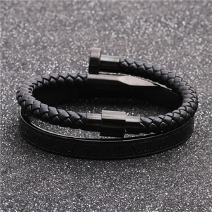 Macro shot of men's black braided leather nail bracelet and Roman numeral steel cuff set