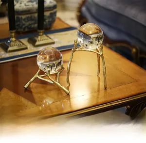 Macro view of clear K9 crystal spheres on luxury golden branch-shaped metal bases