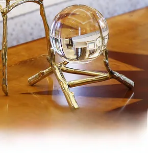 Detailed view of clear crystal ball with star-like textures on a golden branch stand