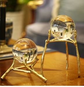 Detail of two crystal balls on golden branch metal stands for modern home decor