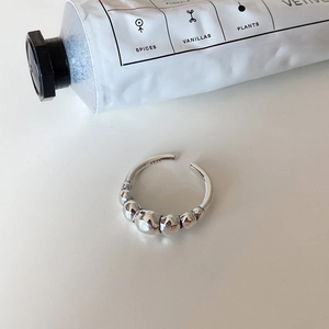 Minimalist 925 sterling silver open ring featuring graduated metal beads on white surface