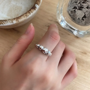 Detailed view of an S925 sterling silver ring with an irregular sphere design on a finger
