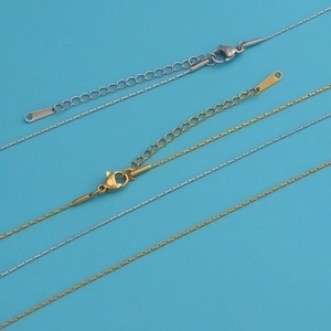 Detailed view of gold and silver stainless steel chains with lobster clasps and S.STEEL tags