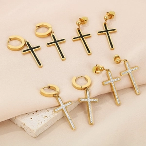 Macro detail of gold cross earrings with black and white rhinestones on stone base