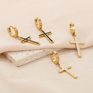 Detail of gold cross hoop earrings with black and white zircon stone inlay for a stylish look