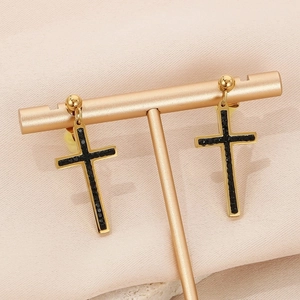 Detail of gold cross earrings with black crystals on a professional metal display stand