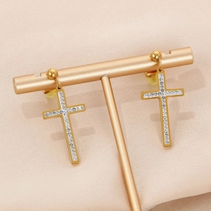 Close-up of gold-plated cross earrings with sparkling white cubic zirconia stones