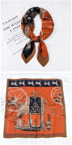 Détail d'un foulard en soie vintage avec motif calèche élégant en orange et noir