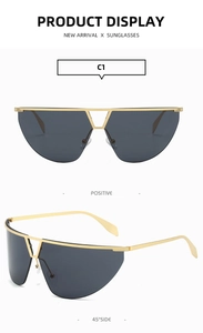Detail view of gold-tone Y2K rimless sunglasses with deep gray one-piece lenses