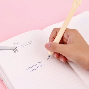 Novelty bone-shaped ballpoint pen in beige plastic being used for writing on a notebook
