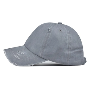 Close-up of washed gray cotton baseball cap with distressed details and frayed edges
