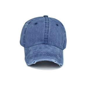 Detailed view of distressed dark blue denim baseball cap with vintage worn-out holes