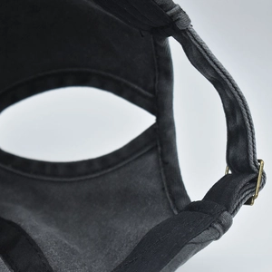 Detail of adjustable metal buckle and ponytail opening on washed charcoal baseball cap
