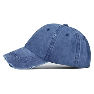 Detailed side view of distressed washed blue denim ponytail baseball cap with torn edges