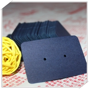 Close-up of small dark blue kraft paper earring display cards with punched holes