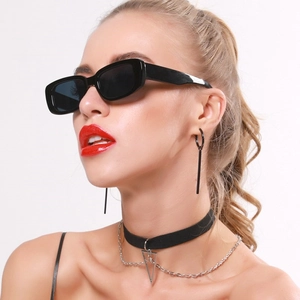 Close-up of retro black narrow rectangle sunglasses and silver geometric jewelry on model